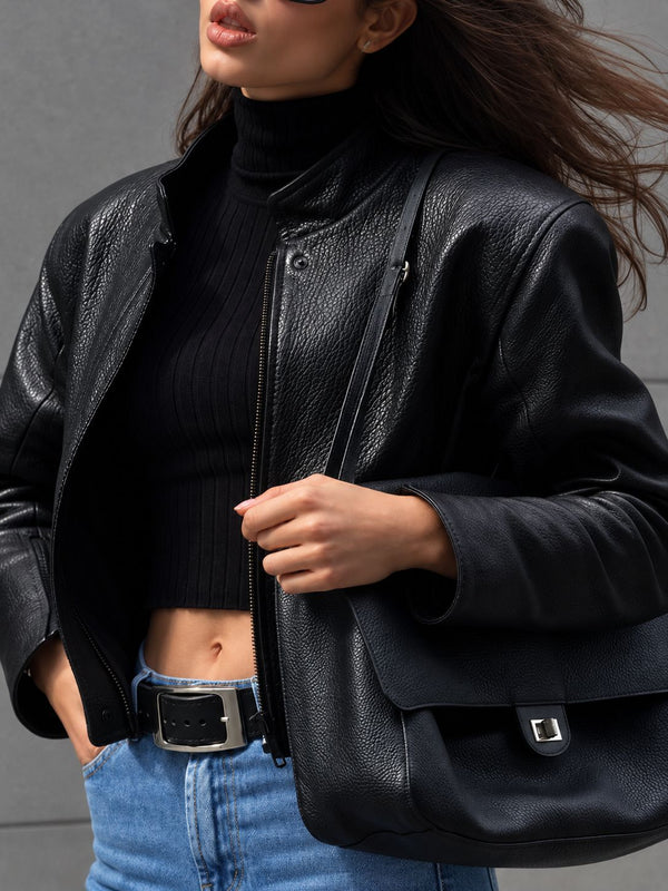 Structured black flap shoulder bag with pebbled texture, silver-tone turn-lock closure, and adjustable single shoulder strap