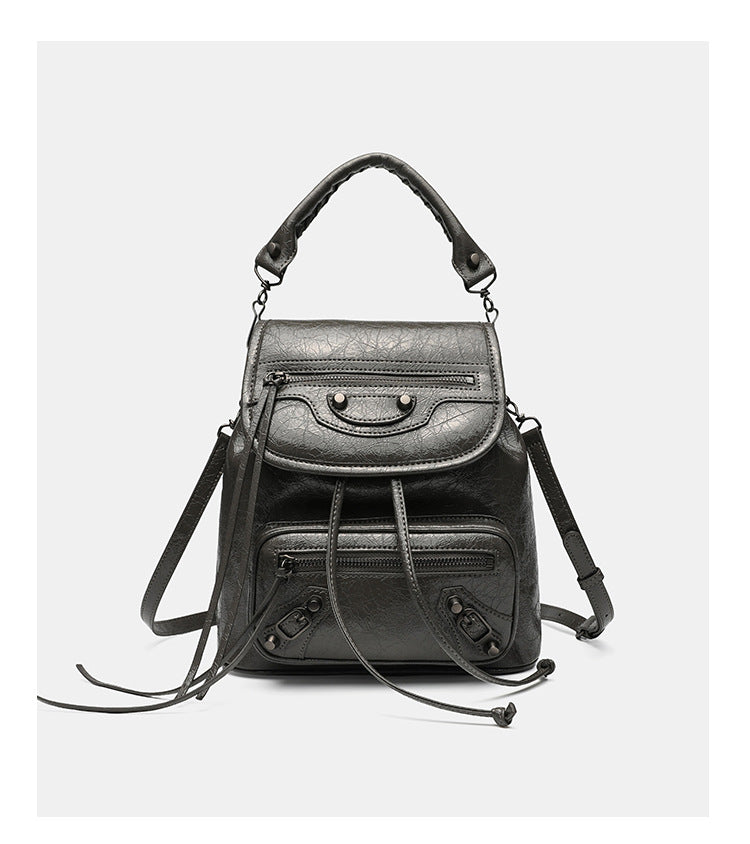 Small structured glossy leather-look convertible backpack handbag in black with flap closure, front zip pockets, metal stud