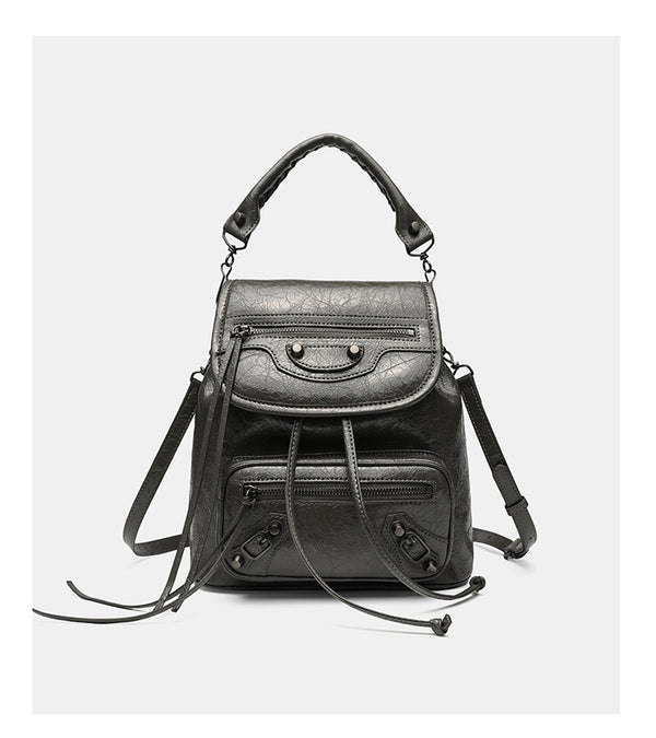 Small structured glossy leather-look convertible backpack handbag in black with flap closure, front zip pockets, metal stud