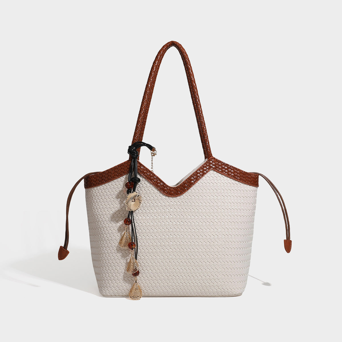 Woven tote bag with braided shoulder straps, drawstring closure, and dangling metal-and-bead charm, detail view 8