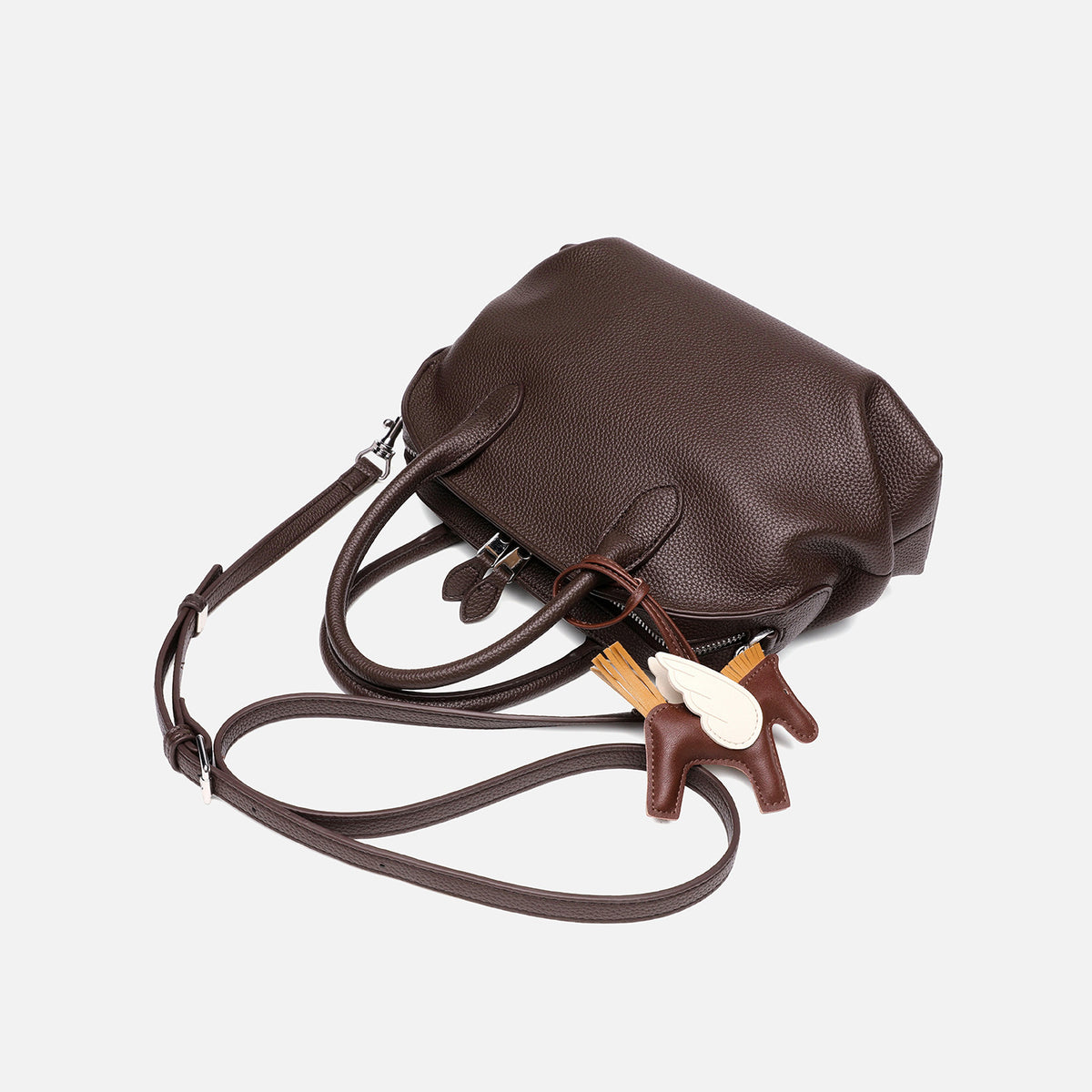 Rounded dome shell handbag in pebbled leather-look finish with twin top handles, zip closure, decorative horse charm, and