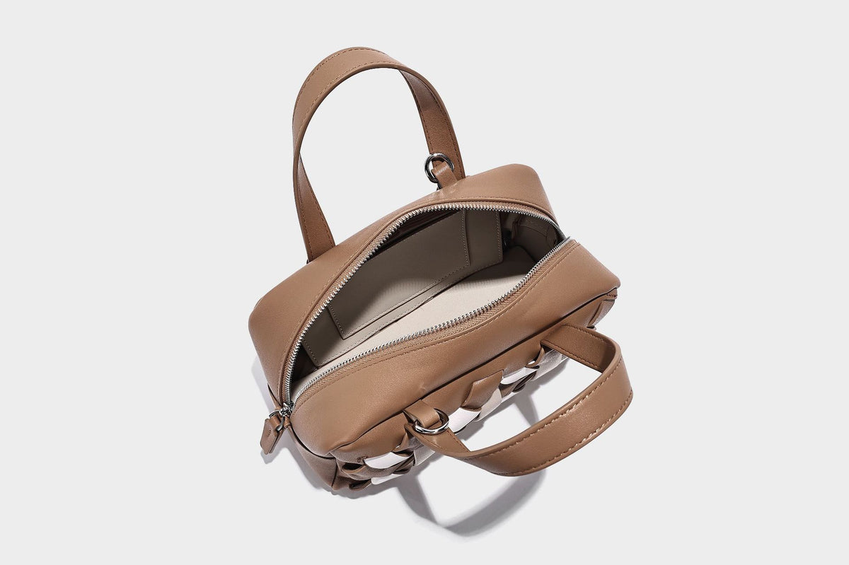 Small structured satchel bag with two-tone woven front panel, dual top handles, and detachable crossbody strap in tan brown