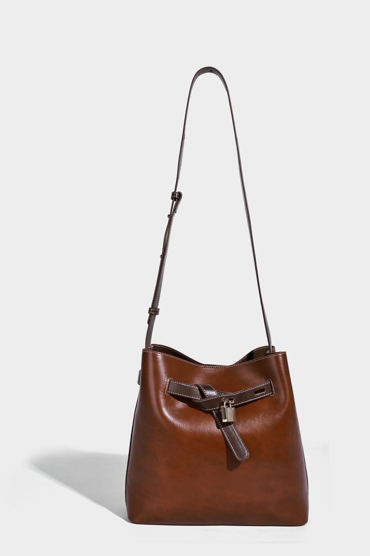 Glänzende Beuteltasche in Lederoptik mit Riemendetail mit Vorhängeschloss und verstellbarem langem Riemen, Detailansicht 19