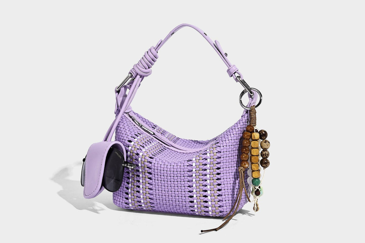 Small woven crescent shoulder bag with leather-look trim, zip closure, silver-tone ring hardware, and beaded tassel charm