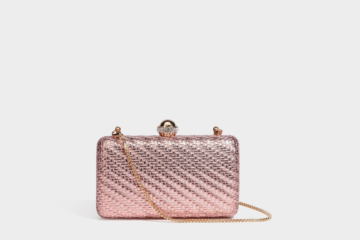 Small structured metallic woven-texture box clutch bag with jeweled kiss-lock dome clasp and slim gold chain strap, detail