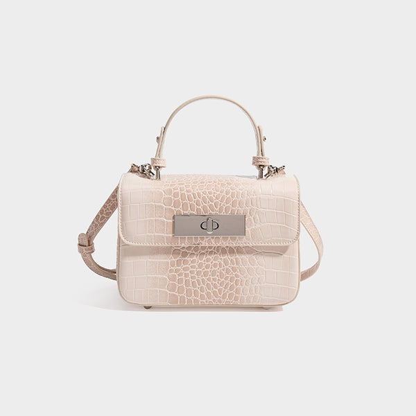 Small structured rectangular satchel with glossy crocodile-embossed finish, arched top handle, front flap, and silver-tone