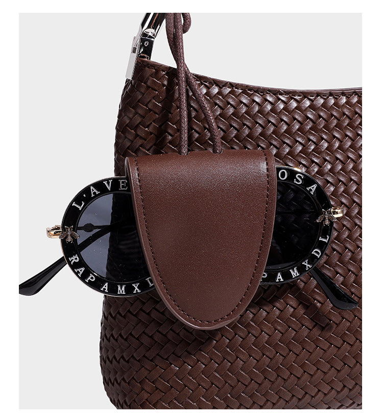Woven-texture hobo shoulder bag in brown with braided top handle, adjustable crossbody strap, front flap pocket, and, detail