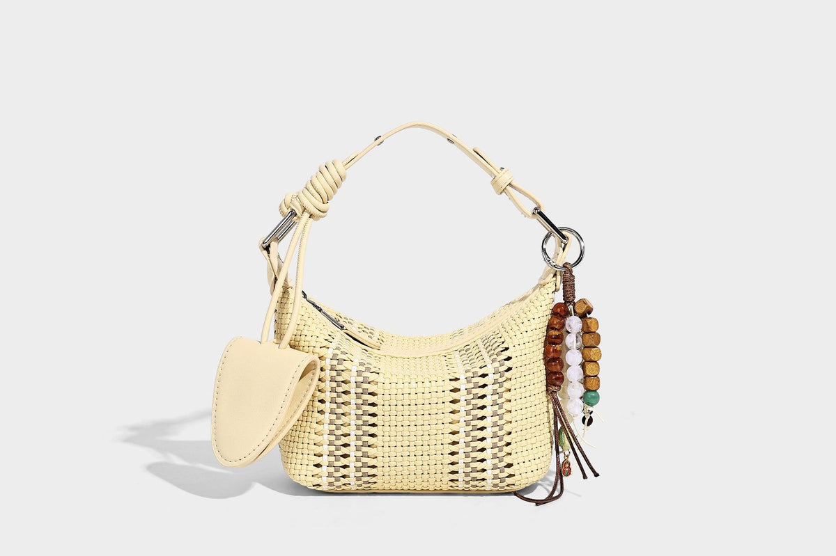 Small woven crescent shoulder bag with leather-look trim, zip closure, silver-tone ring hardware, and beaded tassel charm
