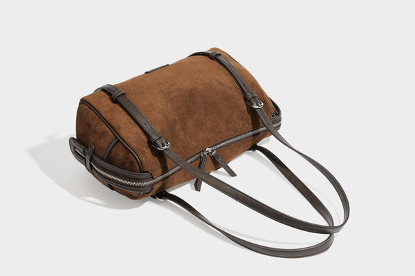 Large brown suede-finish barrel shoulder bag with dark leather-look trim, silver-tone zippers, dual top handles, and long