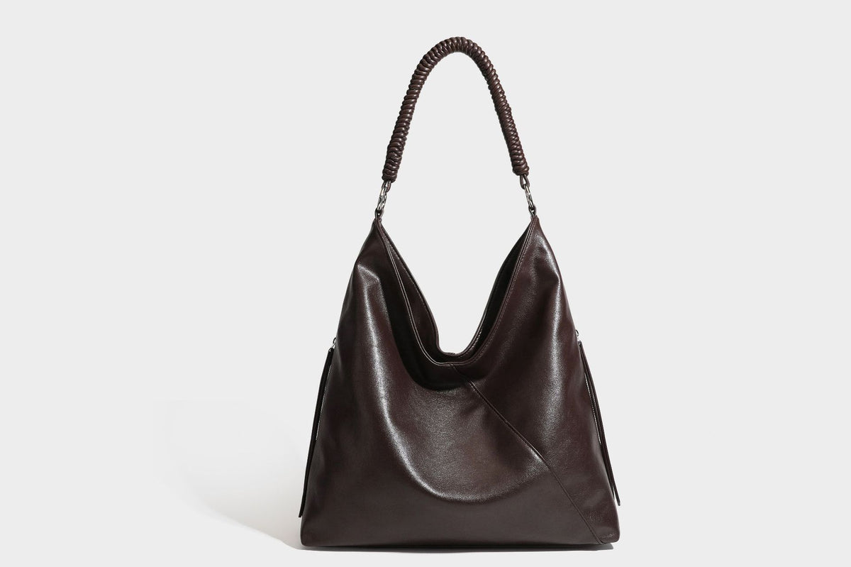 Large slouchy hobo shoulder bag with braided top handle, smooth glossy leather-look finish, and silver-tone ring hardware