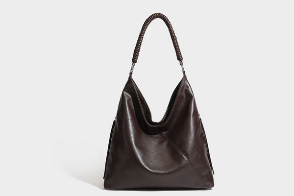 Large slouchy hobo shoulder bag with braided top handle, smooth glossy leather-look finish, and silver-tone ring hardware