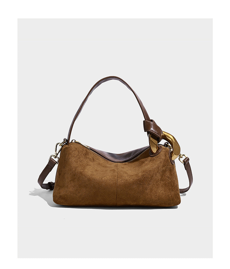 Kompakte Boston-Schultertasche in warmer Braunfarbe mit Wildlederoptik, glatten dunkelbraunen Besätzen, übergroßen goldfarbenen Ringbeschlägen und Reißverschluss oben