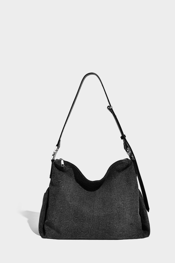 Charcoal denim-textured slouchy hobo bag with zip-top closure, silver-tone hardware, and adjustable leather-look crossbody