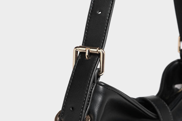 Soft slouchy hobo shoulder bag with smooth leather-look finish, gold-tone buckle and tab hardware, and long adjustable strap
