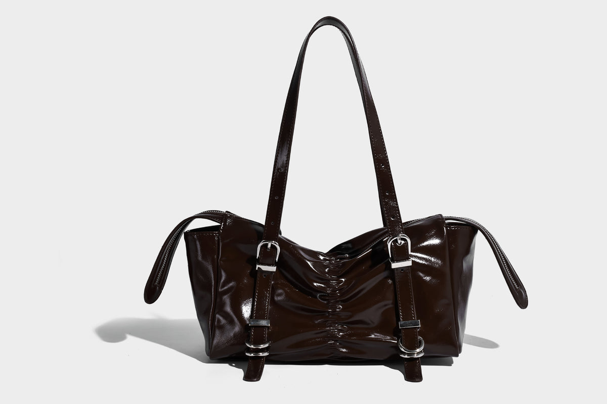 Glänzende, rechteckige Schultertasche mit Raffdetails, zwei verstellbaren Riemen, Reißverschluss oben und Schnallenbeschlägen in Silberoptik
