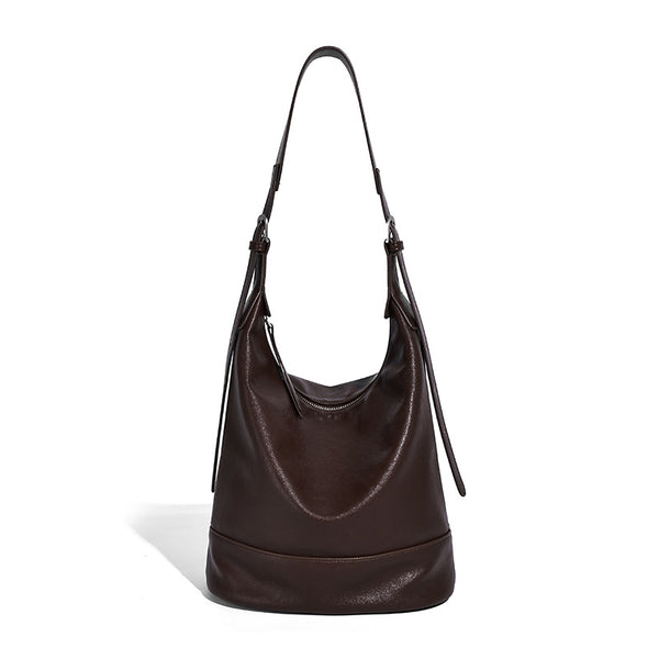 Slouchy bucket hobo shoulder bag in dark brown with glossy leather-look finish, top zip closure, and long adjustable, detail