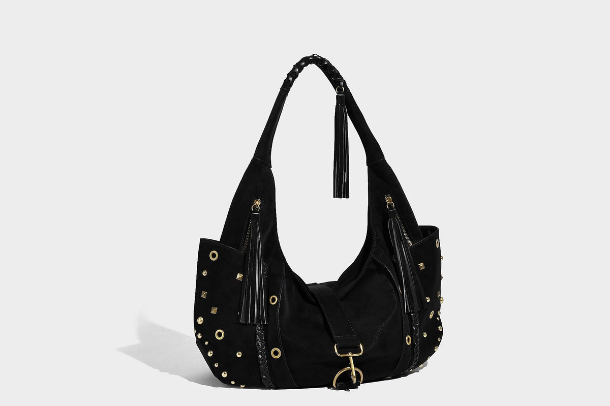 Slouchy crescent hobo bag in matte brown suede-like finish with gold-tone studs, grommets, braided top handle, tassel side