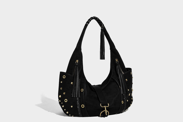Slouchy crescent hobo bag in matte brown suede-like finish with gold-tone studs, grommets, braided top handle, tassel side
