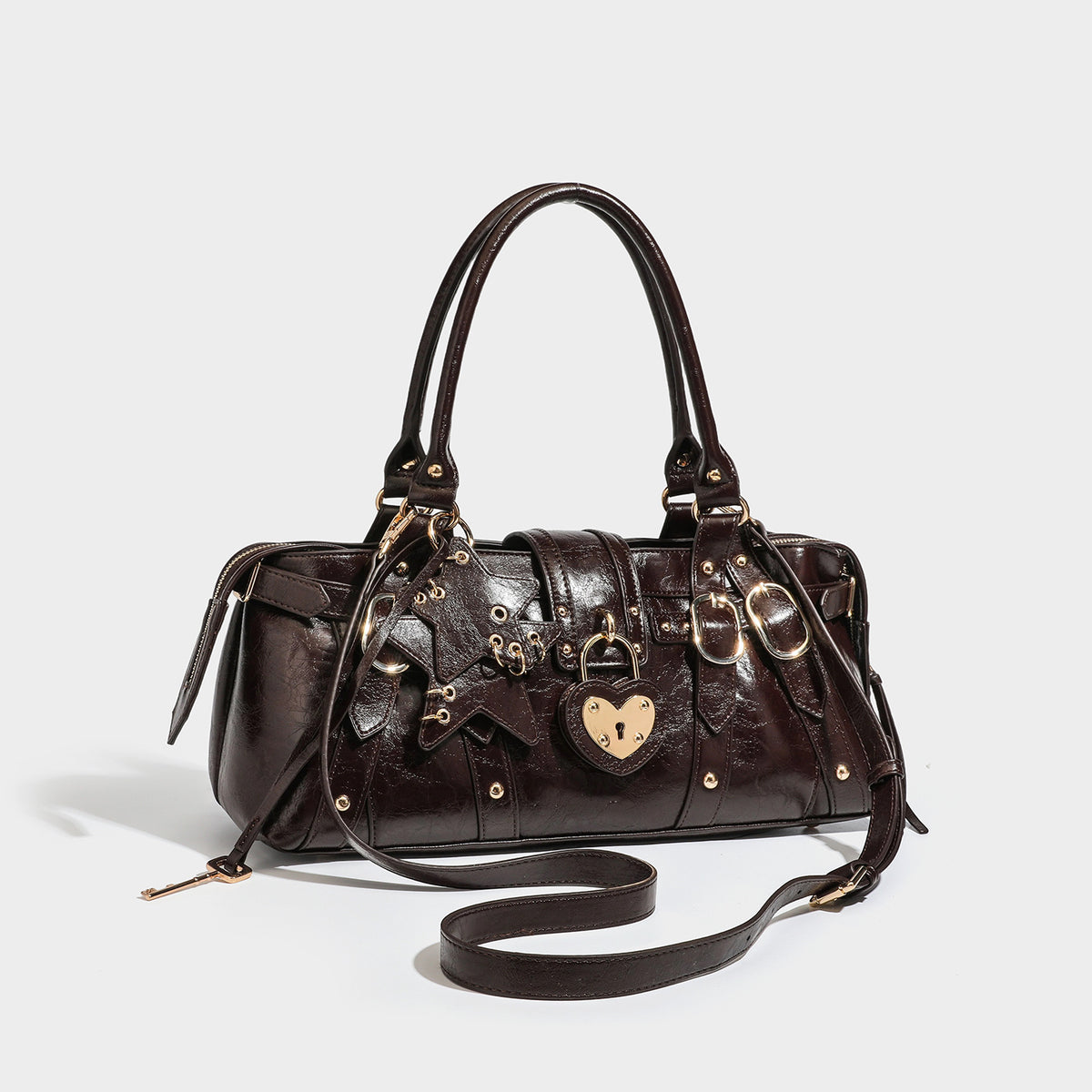 Glossy dark brown structured Boston satchel with heart-shaped lock charm, star pendant, rivet studs, multi-strap front panel