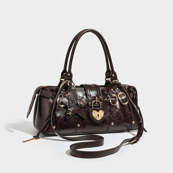 Glossy dark brown structured Boston satchel with heart-shaped lock charm, star pendant, rivet studs, multi-strap front panel