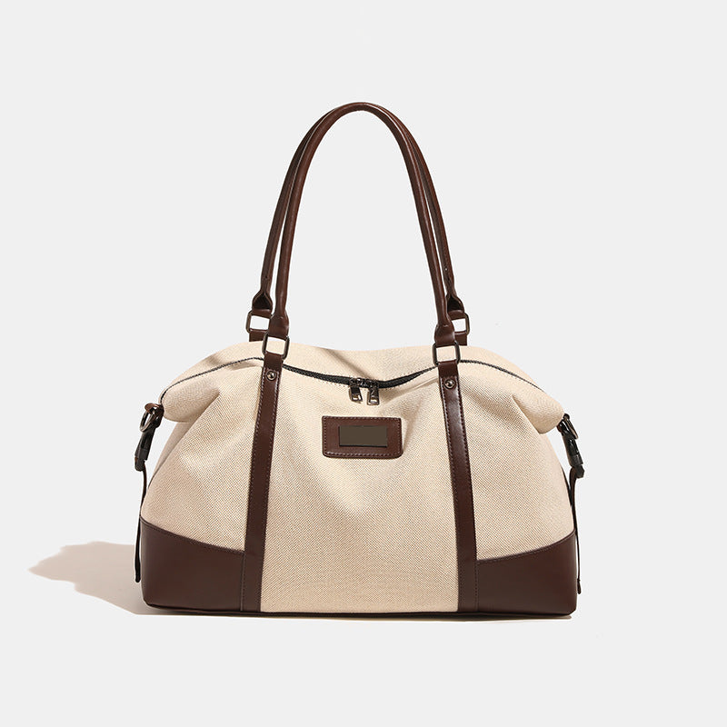 Large cream canvas tote bag with dark leather-look trim, dual top handles, and detachable shoulder strap, detail view 8