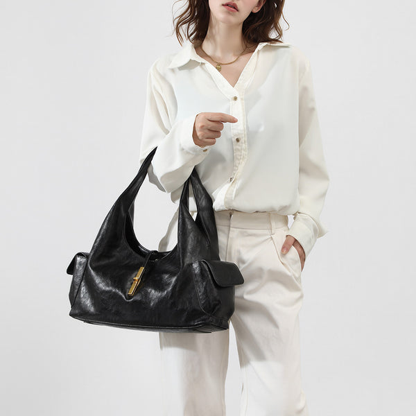 Slouchy leather-look hobo shoulder bag with gold-tone bar clasp and crinkled glossy finish, detail view 2