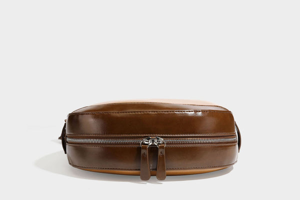 Glossy leather-look crescent hobo shoulder bag with dark contrast trim, silver-tone hardware, and attached mini flap pouch