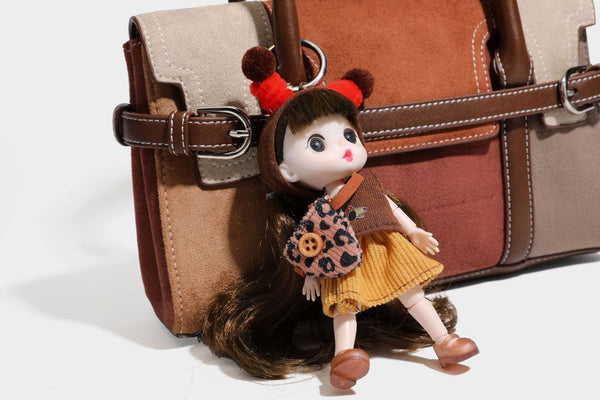 Structured color-block satchel bag in brown, rust, beige, and taupe suede-look panels with white topstitching, front buckle