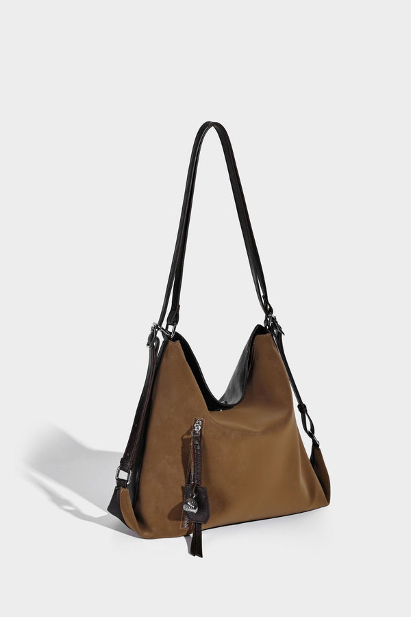 Slouchy hobo tote bag with matte leather-look finish, triangular silhouette, front zip pocket, and adjustable shoulder strap