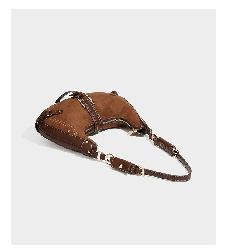 Halbmondförmige Schultertasche in hellbrauner Velourslederoptik mit weißen Kontrastnähten, goldfarbenen Schnallen und
