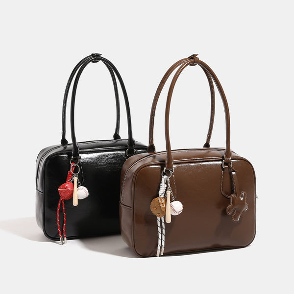 Strukturierte, abgerundet-rechteckige Henkeltasche mit glänzender Oberfläche in Lederoptik und silberfarbenen Beschlägen, Detailansicht