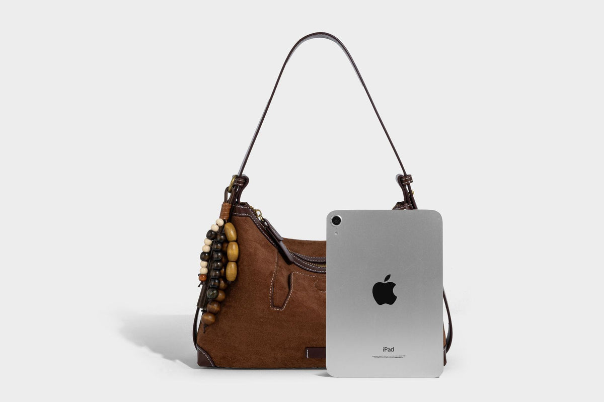 Matte Hobo-Schultertasche in warmem Braun mit dunklem Besatz in Lederoptik, Kontrastnähten, goldfarbenen Metallbeschlägen und