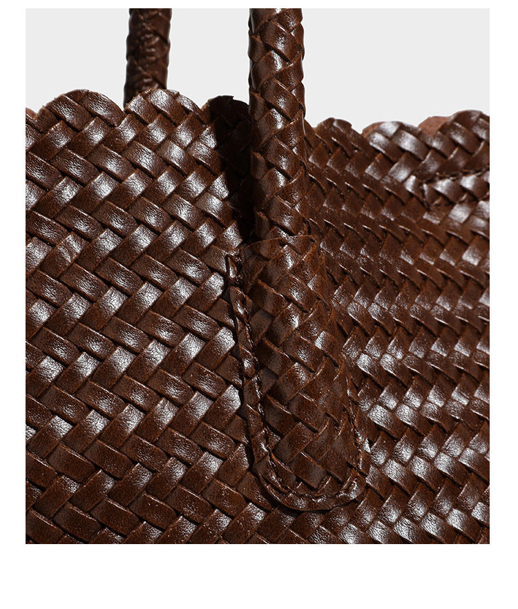 Large open-top woven leather-look tote bag in dark brown with scalloped edge, braided double shoulder straps, and decorative