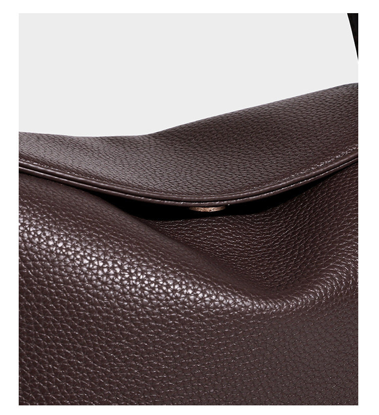 Structured pebbled leather-look shoulder bag with flap top, gold-tone emblem hardware, dual top handles, and detachable