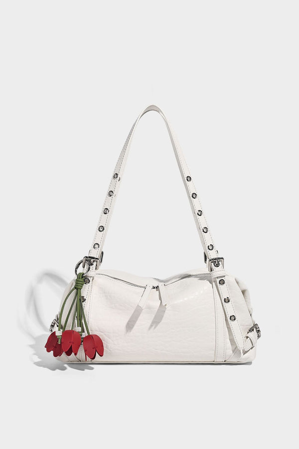 Pale yellow leather-look barrel bag with silver grommet-studded shoulder straps, top zip closure, and pink tulip floral