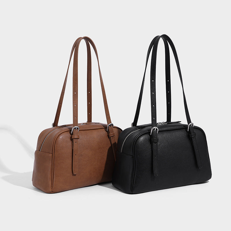 Structured dome-shaped shoulder bag with leather-look finish, top zipper closure, dual adjustable slim straps, and, detail