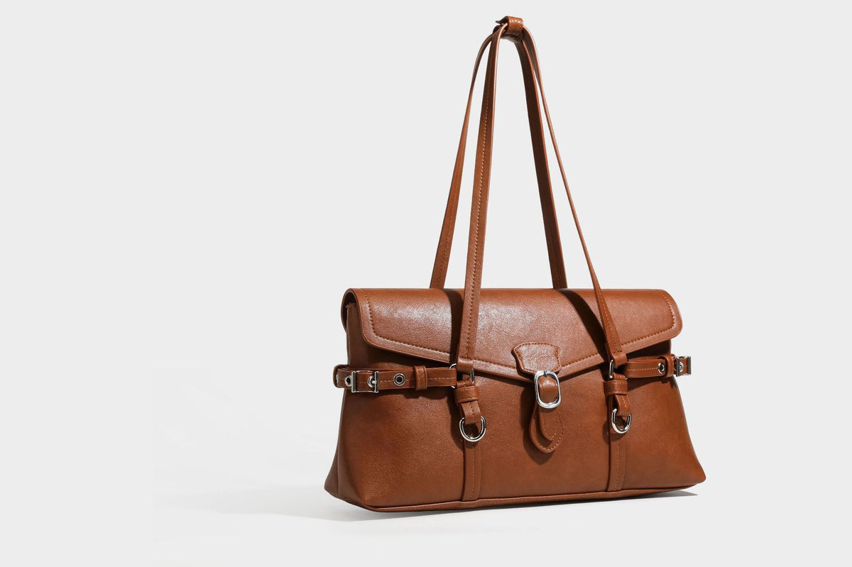 Strukturierte rechteckige Schultertasche mit Überschlagverschluss, vorderem Schnallengurt-Detail und ringförmigen Beschlägen in