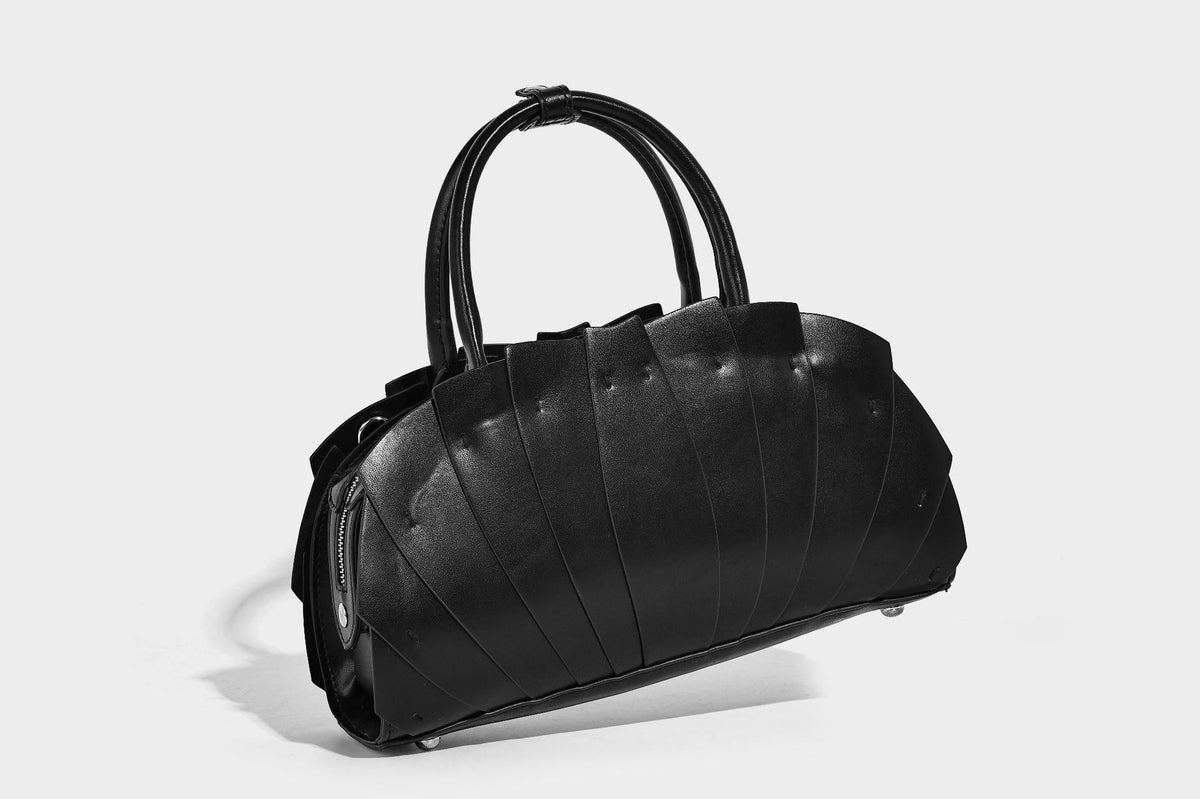 Structured dome satchel with fan-pleated leather-look exterior, dual top handles, and detachable shoulder strap, detail view
