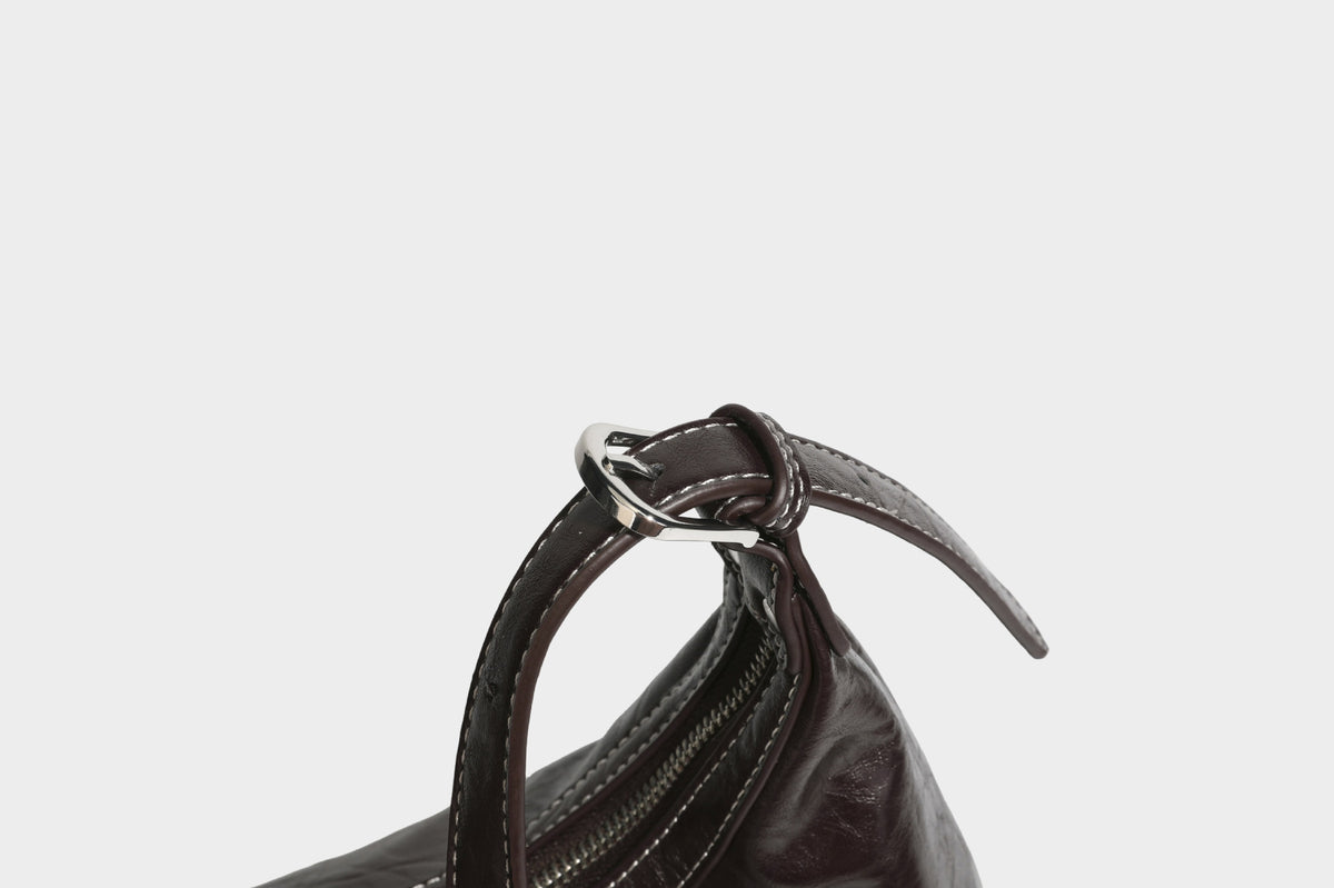 Slouchy hobo shoulder bag in glossy crinkled leather-look finish with zip-top closure and silver-tone ring hardware, detail