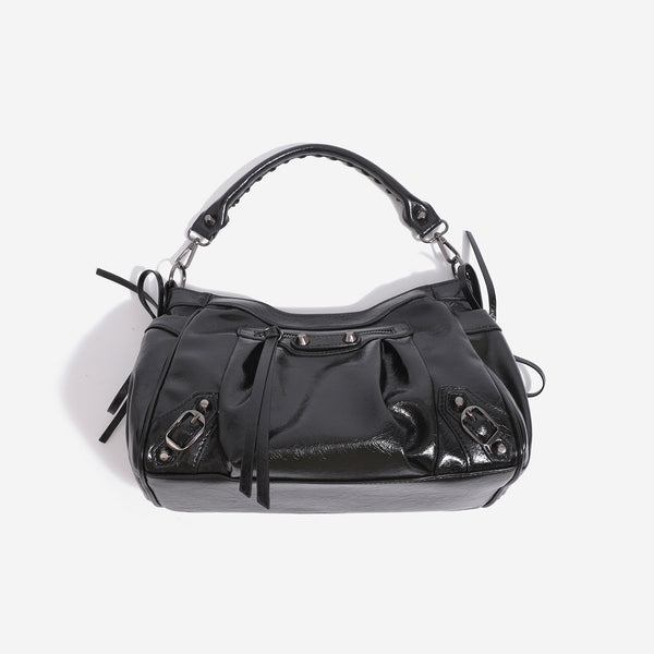 Glossy crinkled slouchy shoulder bag with silver-tone studs, fringe tassel pulls, front zip pocket, and arched top handle