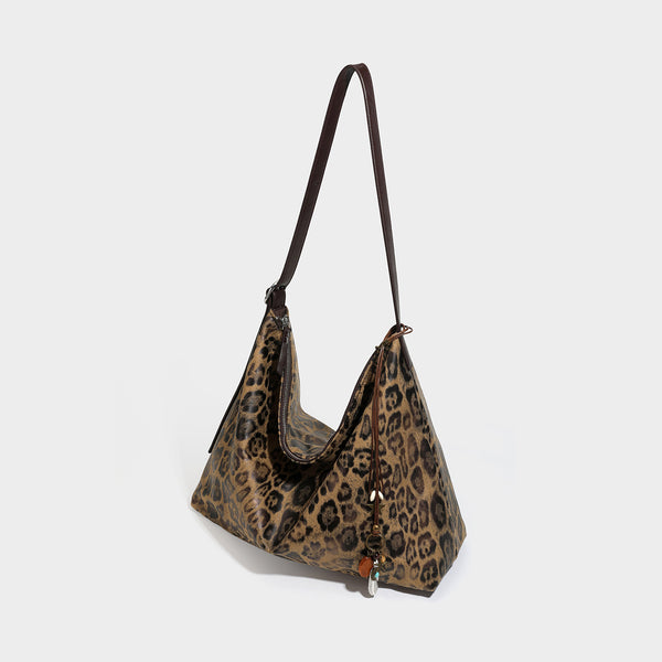 Slouchy leopard print hobo shoulder bag with glossy coated finish, top zipper closure, dark brown trim, and dangling charm