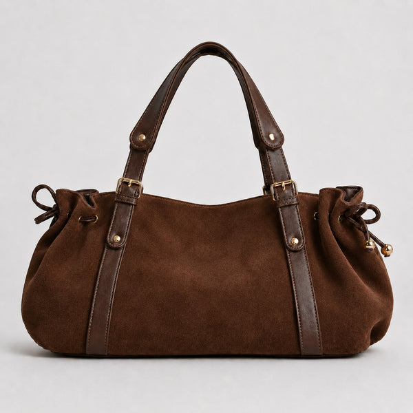 Soft suede-texture shoulder bag in brown with drawstring sides, leather-look vertical straps, gold-tone buckle hardware, and