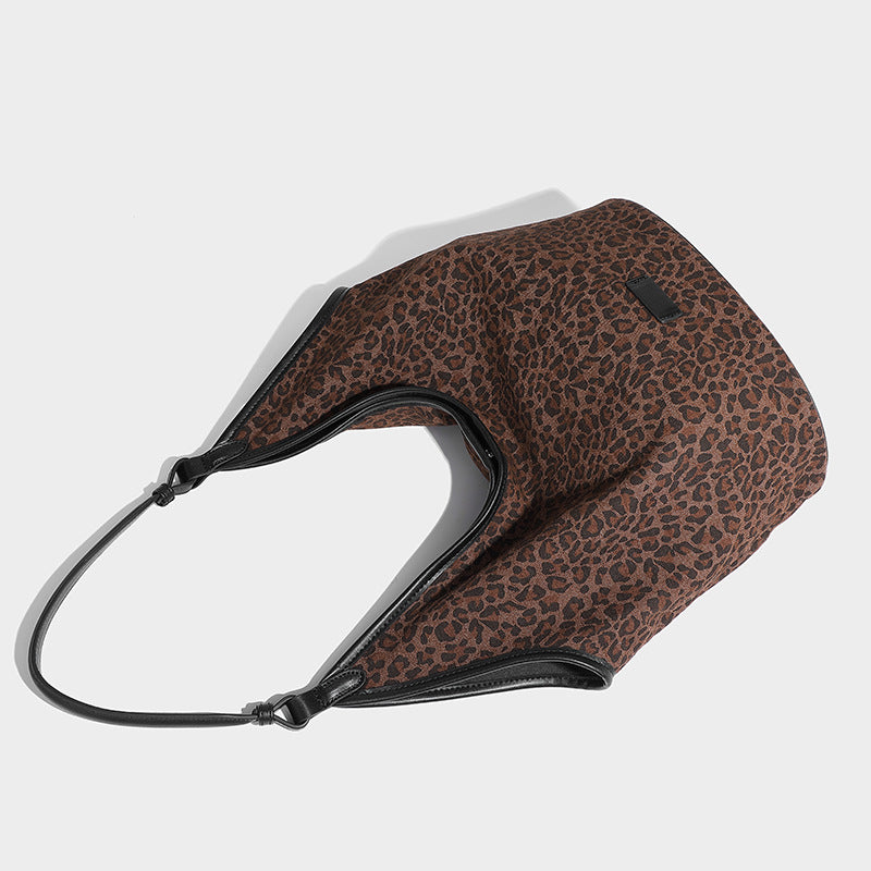 Slouchy brown leopard jacquard hobo tote bag with black leather-look trim and single shoulder strap, shown with black, detail