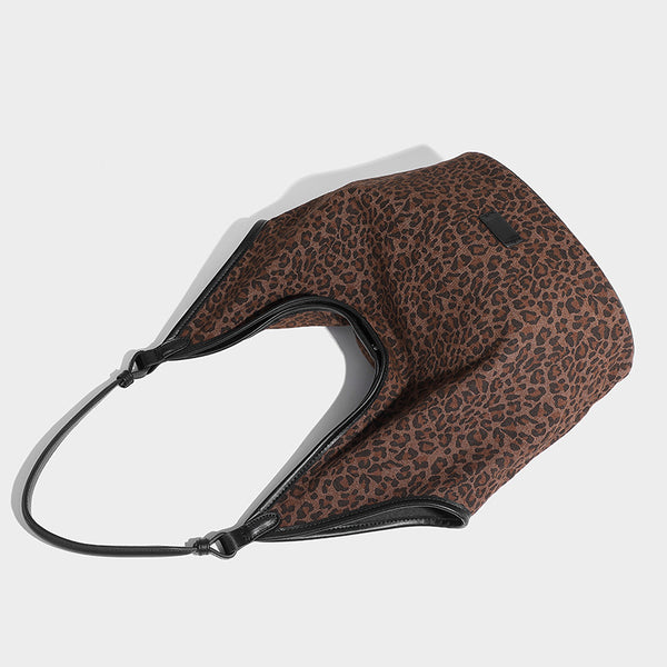 Slouchy brown leopard jacquard hobo tote bag with black leather-look trim and single shoulder strap, shown with black, detail