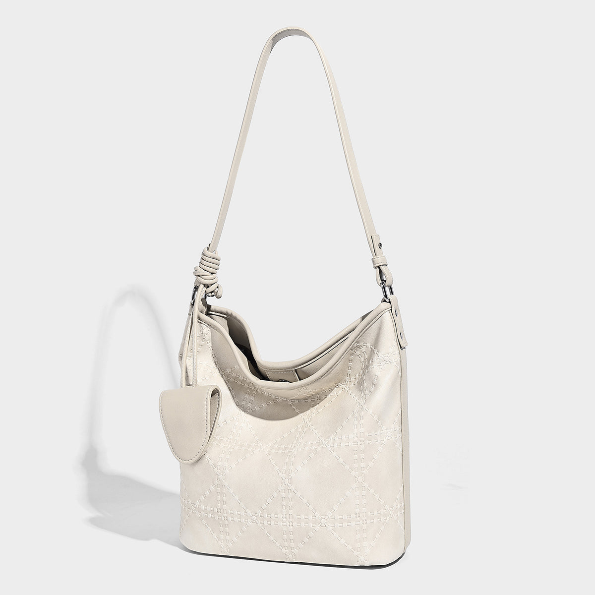 Diamond-quilted leather-look bucket shoulder bag with knotted strap accent and attached mini pouch, detail view 3