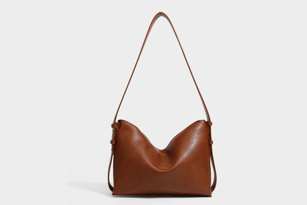 Slouchy suede-finish brown shoulder bag with long single strap and small gold-tone logo emblem on front, detail view 26