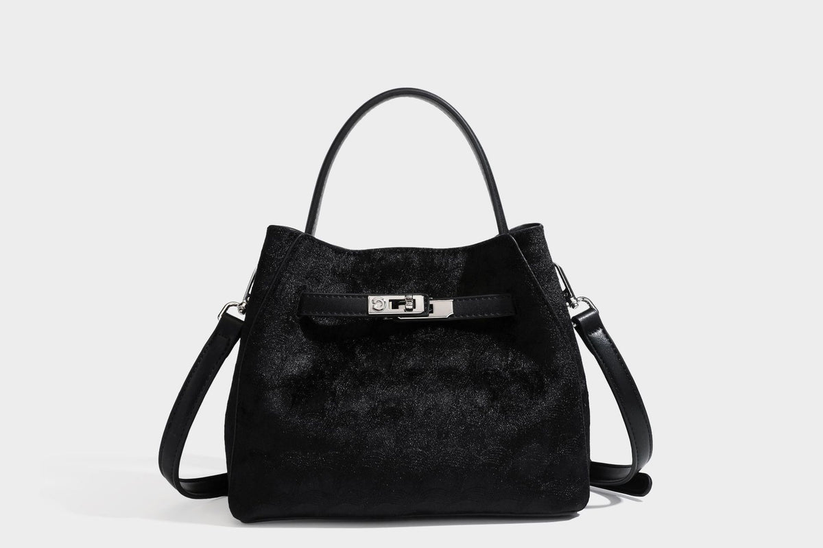 Small structured bucket satchel in embossed velvet-texture fabric with silver turn-lock hardware, rounded top handle, and