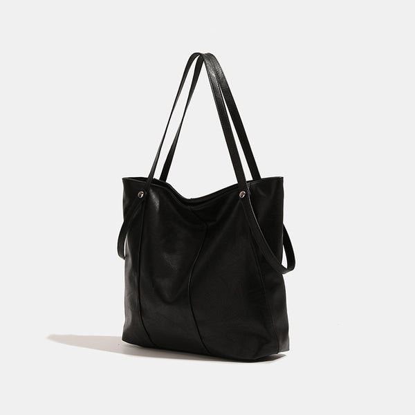 Große, weiche Schultertasche im Tote-Stil aus schwarzer Lederoptik mit zwei flachen Trägern und Nieten in Silberoptik, Vorderansicht