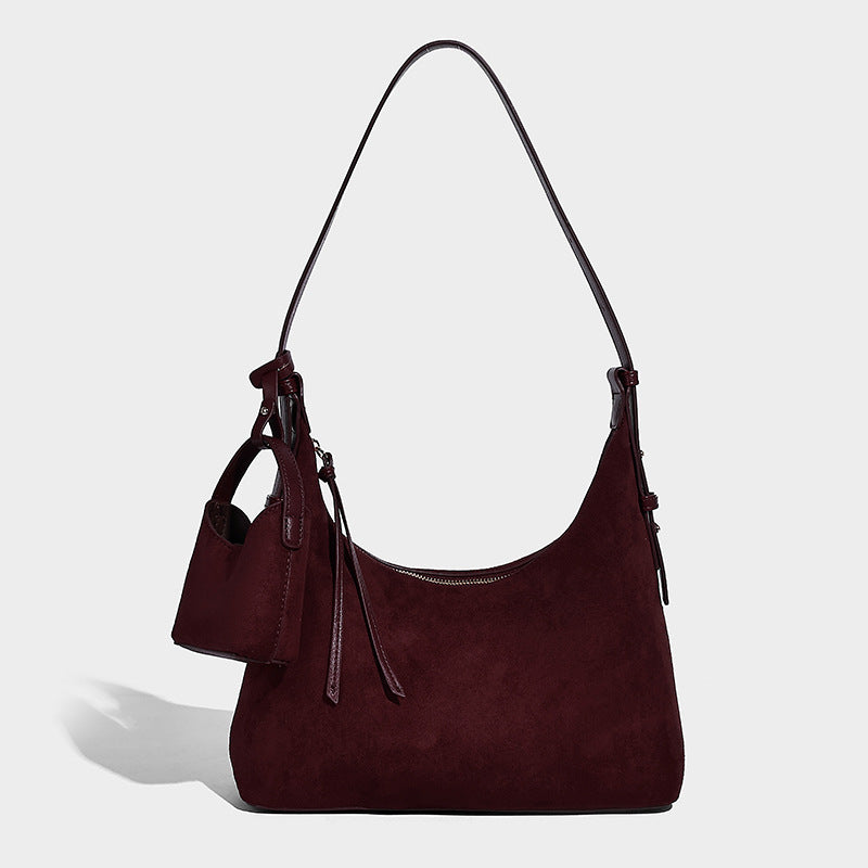 Dark brown suede-look hobo shoulder bag with top zip closure, adjustable strap, and small detachable mini pouch, detail view