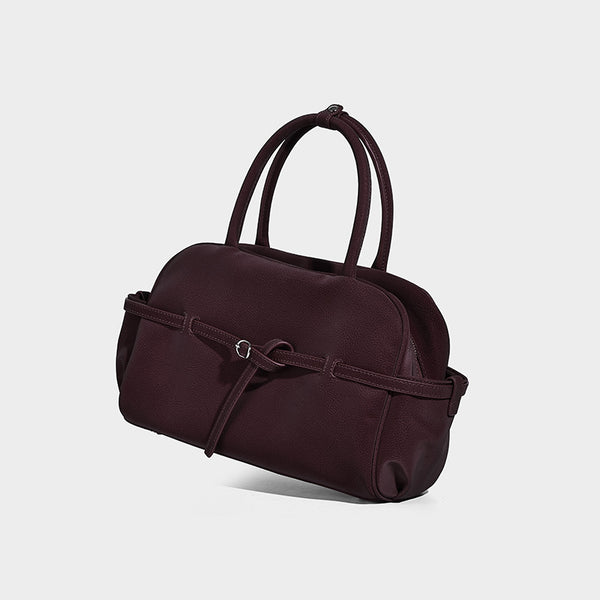 Strukturierte Henkeltasche mit matter, genarbter Oberfläche, umlaufendem Riemen mit Ringbeschlägen, zwei Tragegriffen und abnehmbarem Umhängeriemen